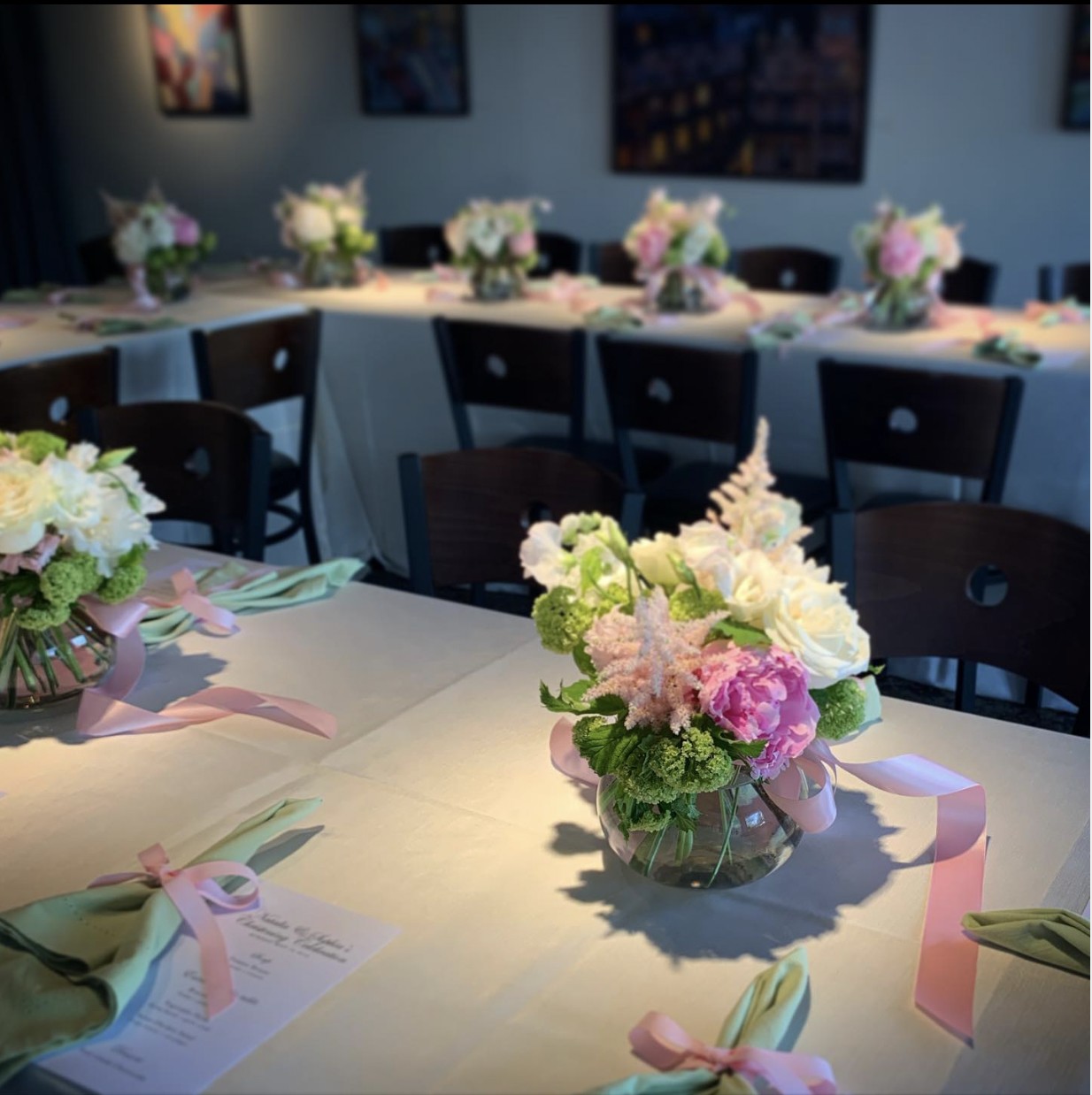 Dining tables set with floral centerpieces and place settings inside The Gallery